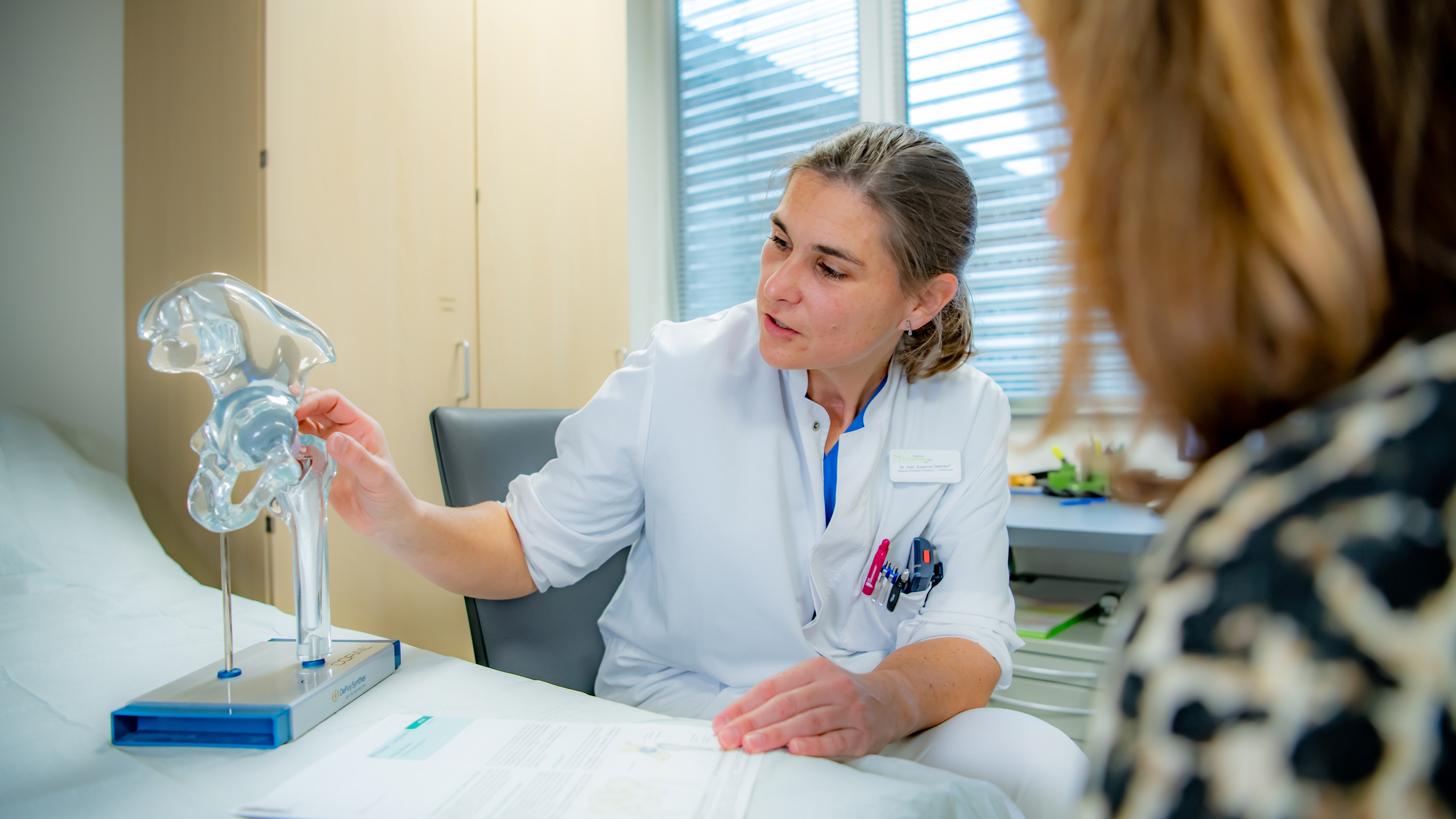 Ärztin mit einem Kunststoffmodell eines Gelenks 